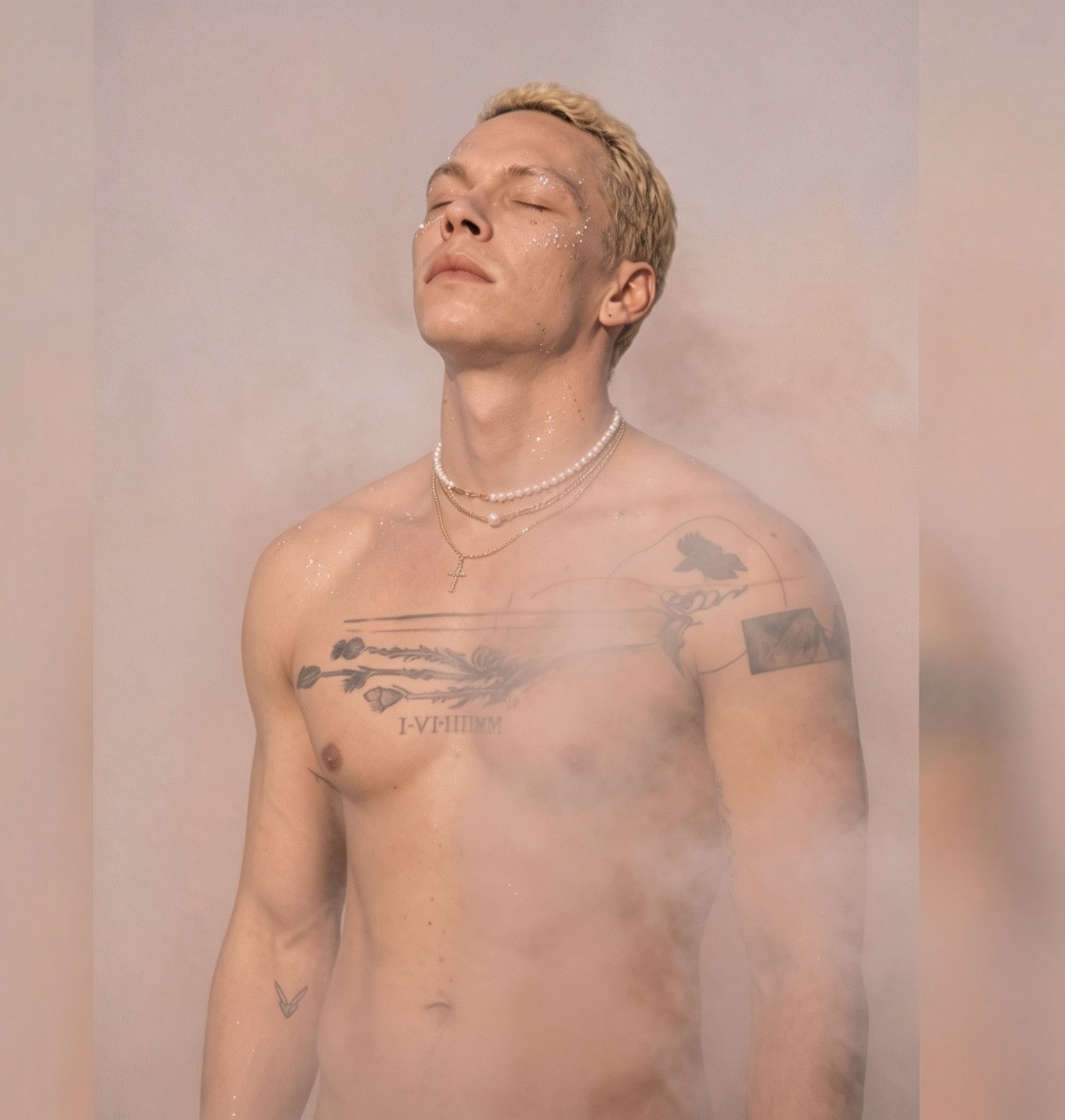 Kaelum in pale mist, glitter on his skin, pearls at his throat, eyes closed